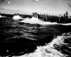 A line of Coast Guard landing barges, sweeping through the waters of Lingayen Gulf, carries the first wave of invaders to the beaches of Luzon, after a terrific naval bombardment of Jap shore positions on Jan. 9, 1945." PhoM1c. Ted Needham. NARA photo.